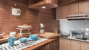 A modern kitchen with wooden cabinets, a stainless steel sink, and a built-in stove. - Love Taipei - Ximen (Taipei)