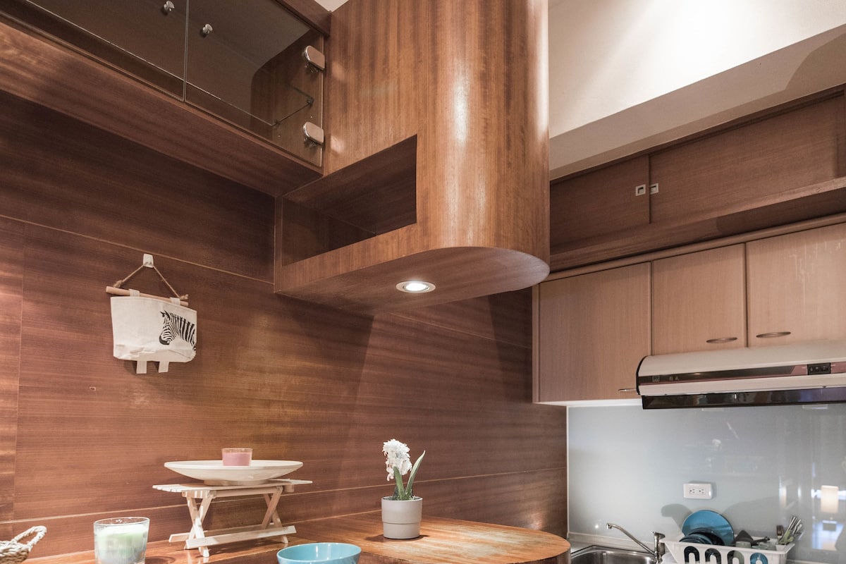 A modern kitchen with wooden cabinets, a stainless steel sink, and a built-in stove.