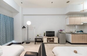 A compact hotel room with a bed, a desk with a TV, a small kitchenette, and a bathroom with a shower. - Love Taipei - Ximen (Taipei)