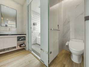 Un baño moderno con ducha de vidrio, inodoro blanco y tocador con lavamanos.