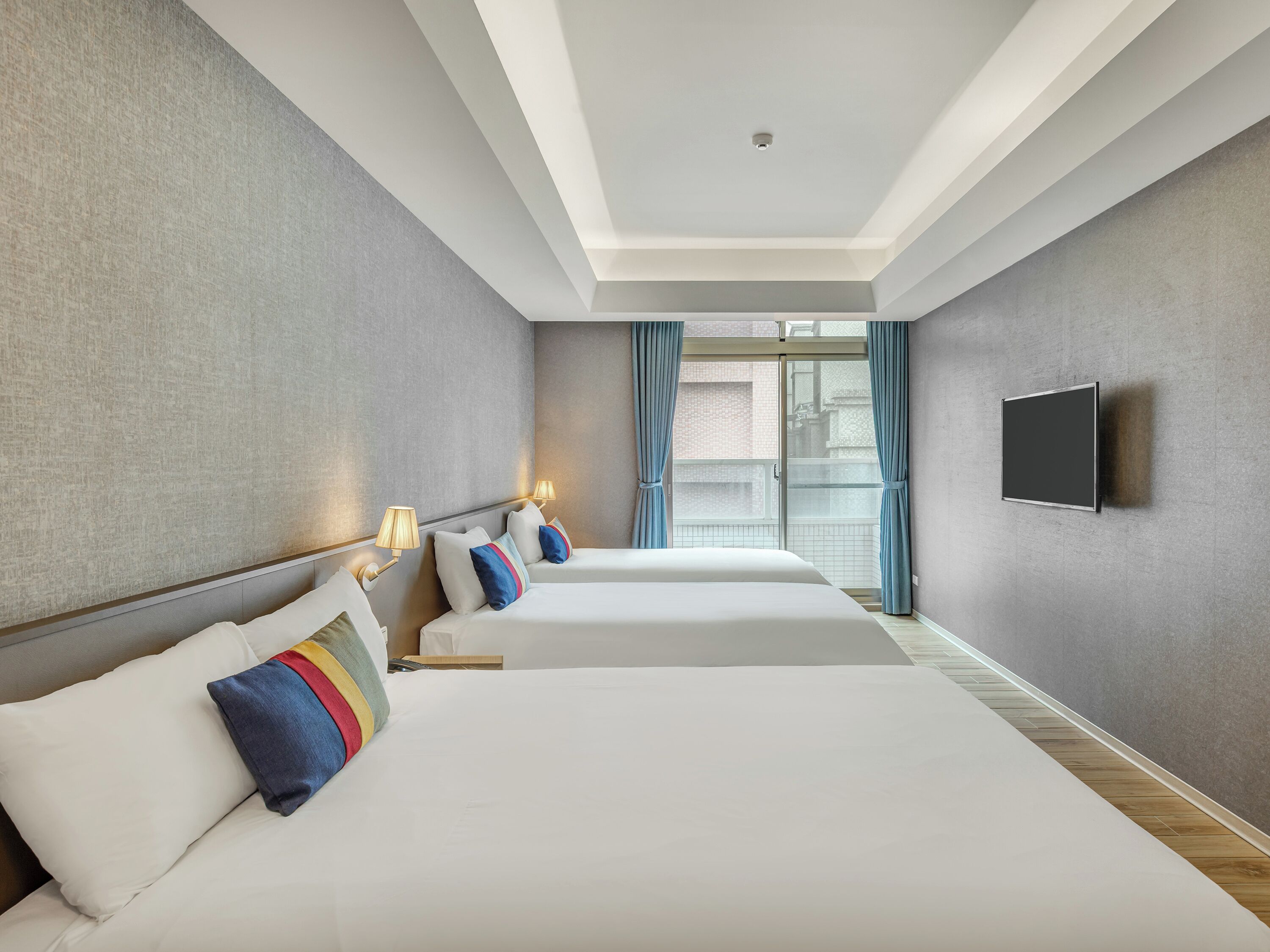Quarto de hotel com duas camas, televisão de tela plana e vista para o exterior.