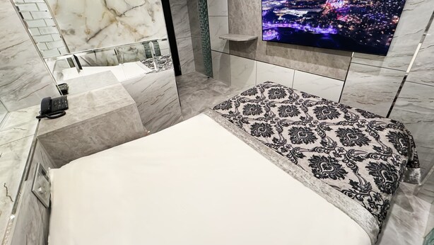 Une salle de bain moderne avec un meuble-lavabo en marbre, une baignoire et un grand miroir.