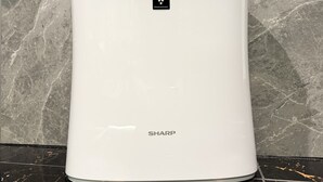 A white SHARP water heater with a control panel, standing on a black tiled floor against a marble wall. - Hotel Rocks (Tokyo)