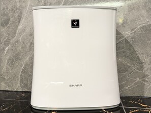 A white SHARP water heater with a control panel, standing on a black tiled floor against a marble wall. - Hotel Rocks (Tokyo)