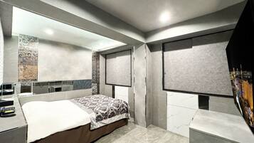 Quarto moderno com uma cama grande, uma mesa de cabeceira, um espelho e um guarda-roupa.