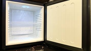 An open refrigerator with a clear interior, a control panel, and a freezer compartment.