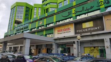A multi-story commercial building with various storefronts, including a bank and retail stores.