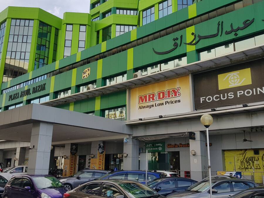 Un edificio de varios pisos con locales comerciales, incluyendo un banco y tiendas.