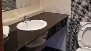 A modern bathroom with a white sink, a mirror, and a toilet. - Abdul Razak Hotel Apartment (Bandar Seri Begawan)