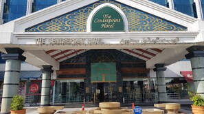 The Centrepoint Hotel entrance with a green sign, marble facade, and columns. - The Centrepoint Hotel (Bandar Seri Begawan)