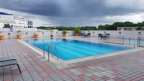 A rooftop swimming pool with tiled flooring, metal railings, and potted plants. - The Centrepoint Hotel (Bandar Seri Begawan)