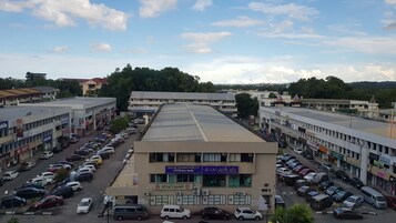 Un edificio comercial de varios pisos con tiendas diversas y un estacionamiento.