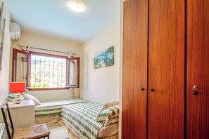 A bedroom with a bed, a desk, a chair, a wardrobe, and a window with curtains. - Club Villamar - Nice villa with airco, wifi, fenced private swimming pool nearby Calonge (Calonge)