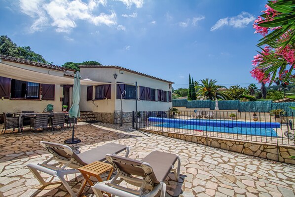 A poolside area with lounge chairs, a covered seating area, and a swimming pool. - Club Villamar - Nice villa with airco, wifi, fenced private swimming pool nearby Calonge (Calonge)