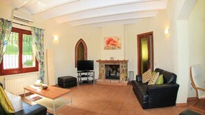 A spacious living room with a fireplace, a television, and comfortable seating. - Club Villamar - Nice villa with airco, wifi, fenced private swimming pool nearby Calonge (Calonge)