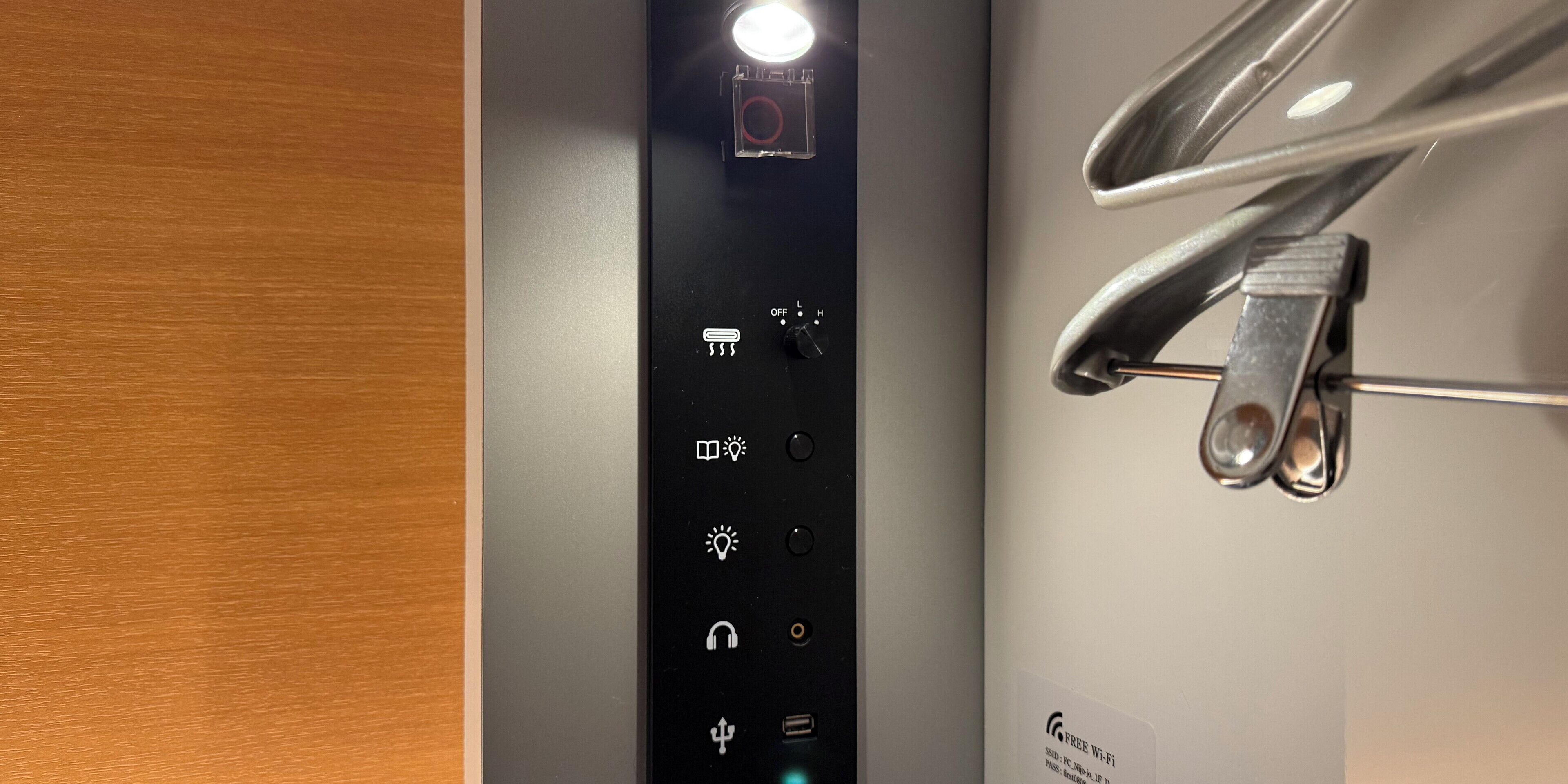 Een bedieningspaneel met diverse pictogrammen voor kamers, waaronder een lichtschakelaar, temperatuurregeling en andere functies.