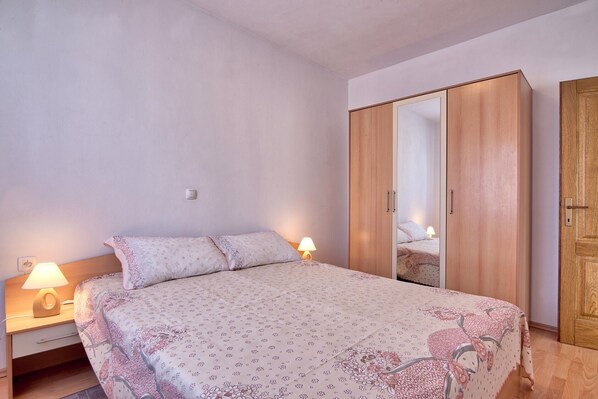 A bedroom with a bed, nightstands, a wardrobe, and a mirror. - Apartments Maja 450 m from the beach - Apt 3 (Fažana)
