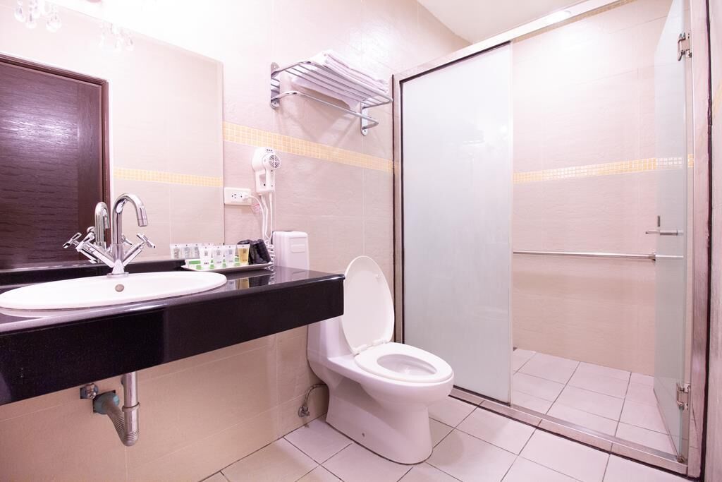 A bathroom with a sink, mirror, and toilet.