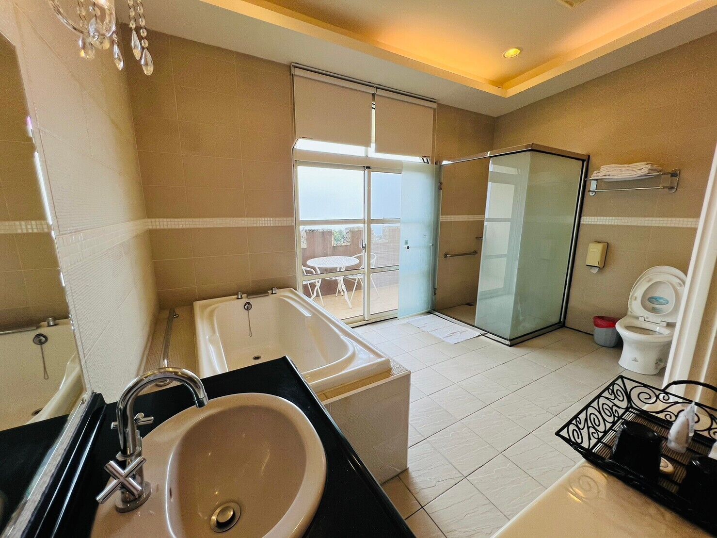 A modern bathroom with a bathtub, sink, toilet, and glass shower enclosure.