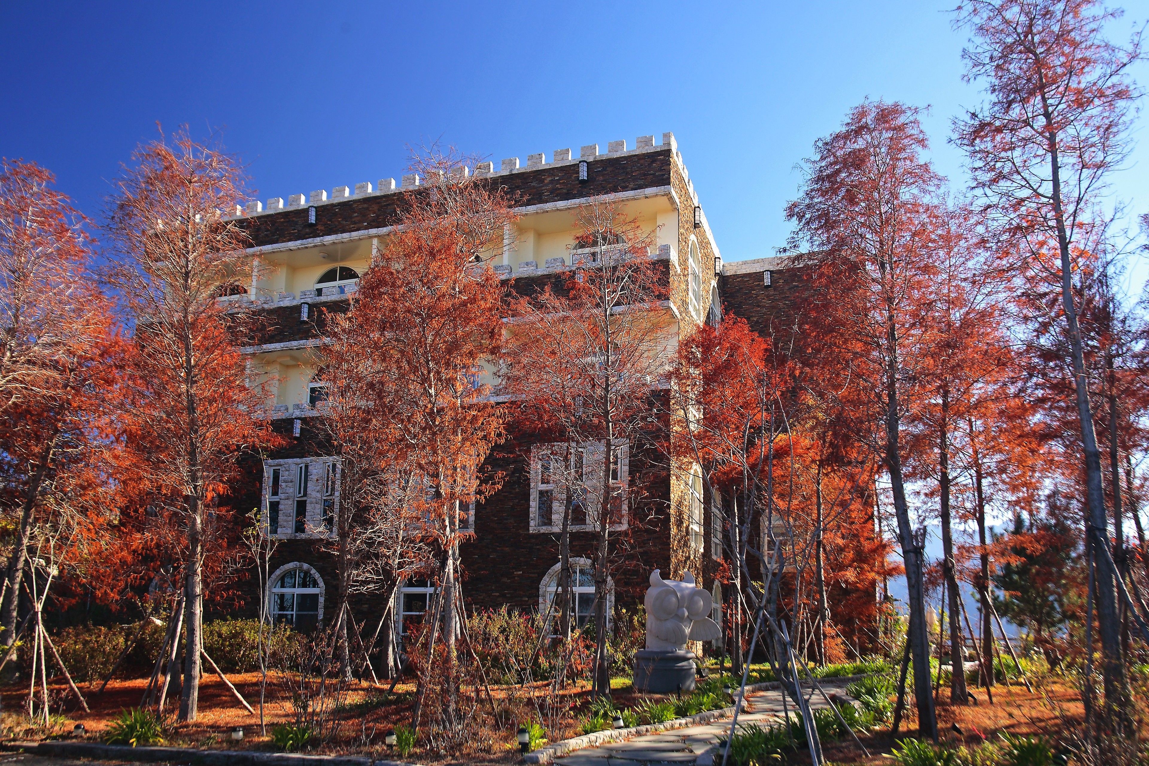 A historic building with a stone facade, multiple windows, and a balcony.