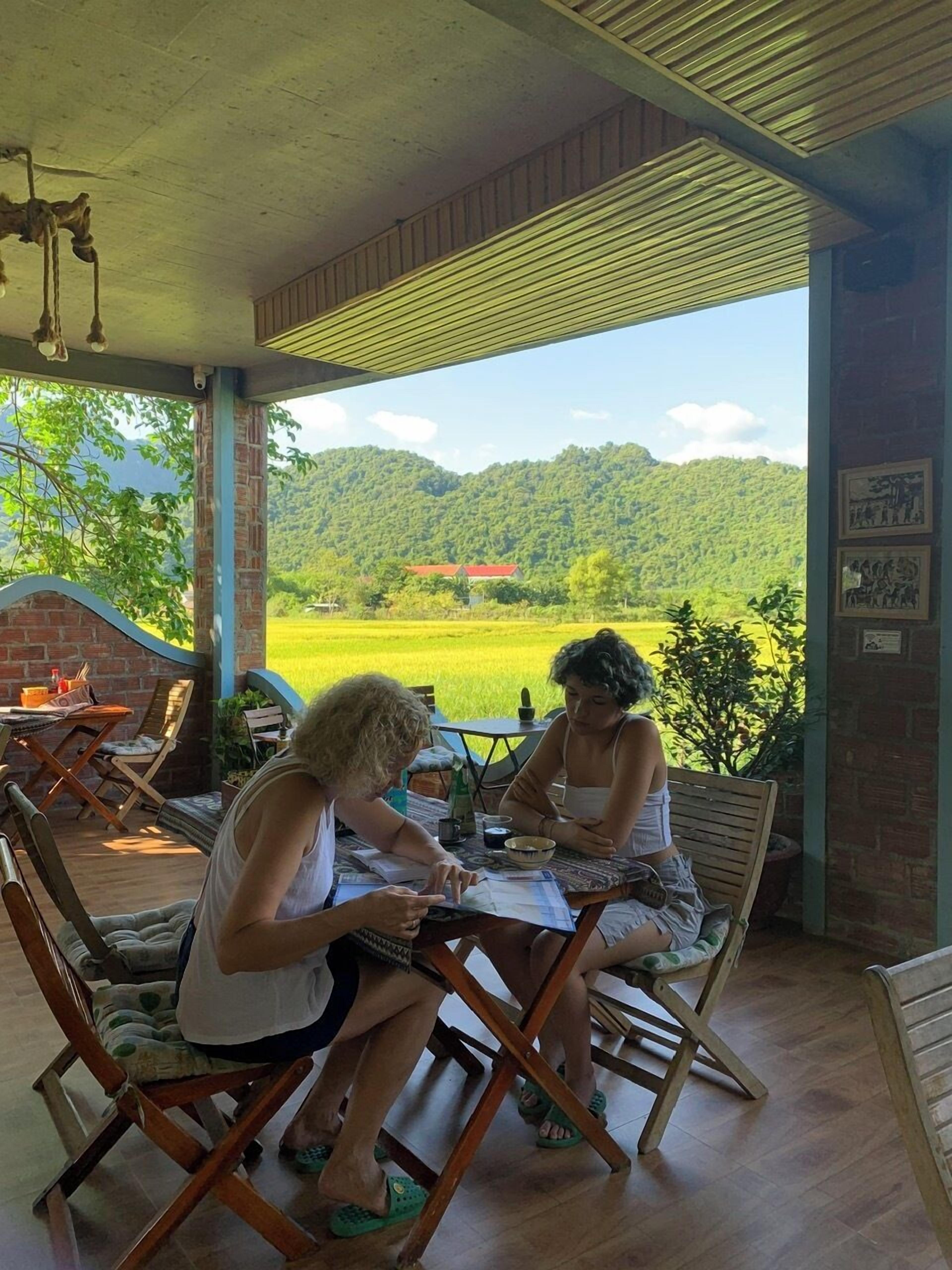 Un espacio de estar al aire libre cubierto, con paredes de ladrillo y mobiliario de madera.