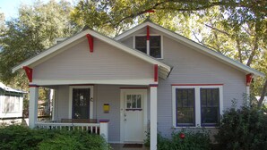 A two-story house with a front porch, a door, and two windows. - Cool Updated Craftsman Bungalow (Austin)