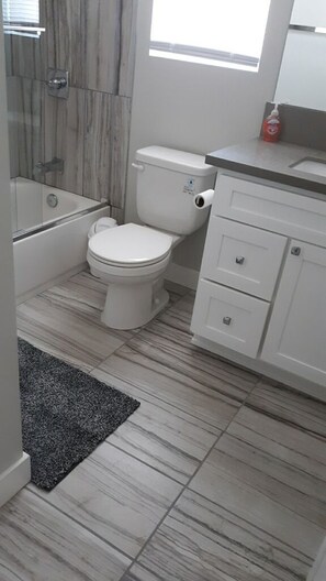 A bathroom with a toilet, a bathtub, and a shower area. - Luxury Stays - Hostel (Inglewood)