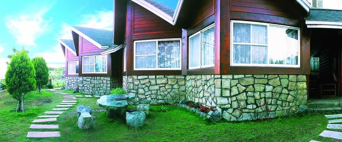 A modern house with stone walls and a stone pathway leading to the entrance.