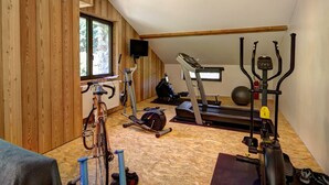 A gym with a wooden interior, exercise equipment, and a window. - Authentic cottage with fireplace, pets allowed and WiFi by the forest (La Versanne)