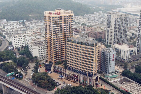 Un edificio alto con varios pisos, rodeado de otros edificios.