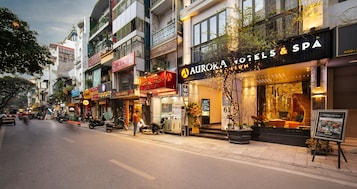 A street view of a hotel with a prominent sign for 'AURORA HOTELS & SPA'.