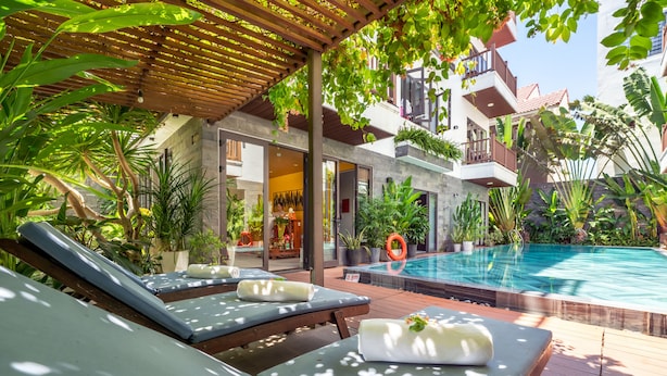 A poolside area with lounge chairs, a wooden pergola, and a small pool. - December Hoi An Villa (Da Nang)