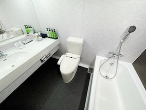 A modern bathroom with a white sink, toilet, and bathtub. There are green and white toiletries on the sink. - Hotel Gran Villa (Tokyo)