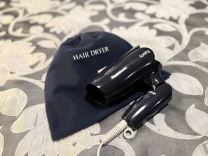 Een haardroger en een pet met de tekst 'HAIR DRYER' en 'ionity' op een achtergrond van gestreken stof.