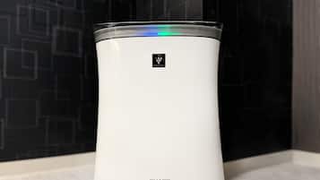 A white, cylindrical device with a control panel and the brand name 'SHARP' on a light-colored wooden surface.