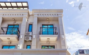 A multi-story building with a classical architectural style, featuring columns, balconies with ornate railings, and large windows. - Art Ocean (Tainan)