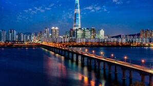 A cityscape with a prominent skyscraper, a waterfront, and a bridge. - MG Hotel Jonggak (Seoul)