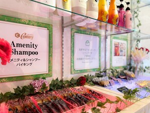 Mostra d'hotel amb diverses comoditats, inclosa una placa amb la inscripció 'Amenity Shampoo' i una selecció de productes a les prestatgeries.