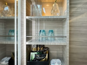 A bathroom with a mirrored wall, a shelf with toiletries, and a decorative crystal. - Hotel Century (Chiba)