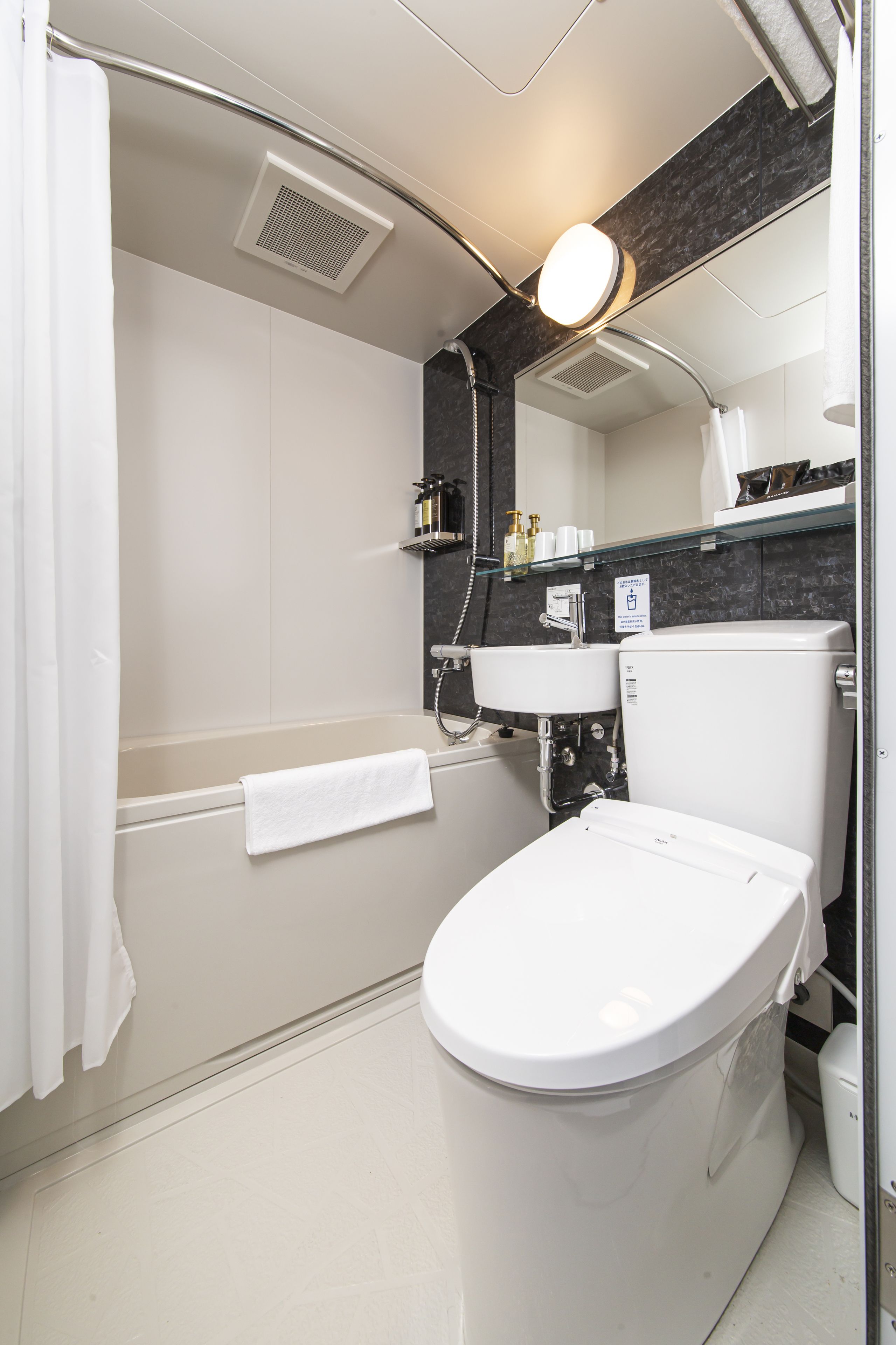 A modern bathroom with a bathtub, toilet, and sink.