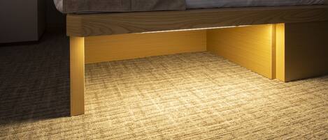 A bed with a wooden frame and a mattress on a carpeted floor.