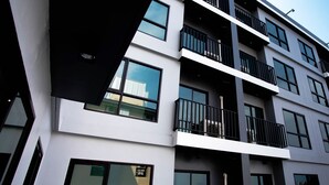 Un immeuble à plusieurs étages doté de balcons, de grandes fenêtres et d’un style architectural moderne.