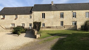A stone building with multiple windows and a gravel driveway. - APARTMENT 1.5 kms FROM THE LANDING BEACHES  (Tracy sur Mer)