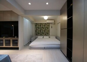 A bedroom with a bed, a TV, and built-in wardrobes. - TokyoGuest Nihonbashi (Tokyo)