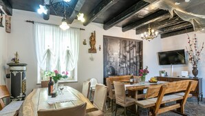 Ein Essbereich mit Holztisch und Stühlen, einer Kronleuchter und einem großen Gemälde an der Wand.