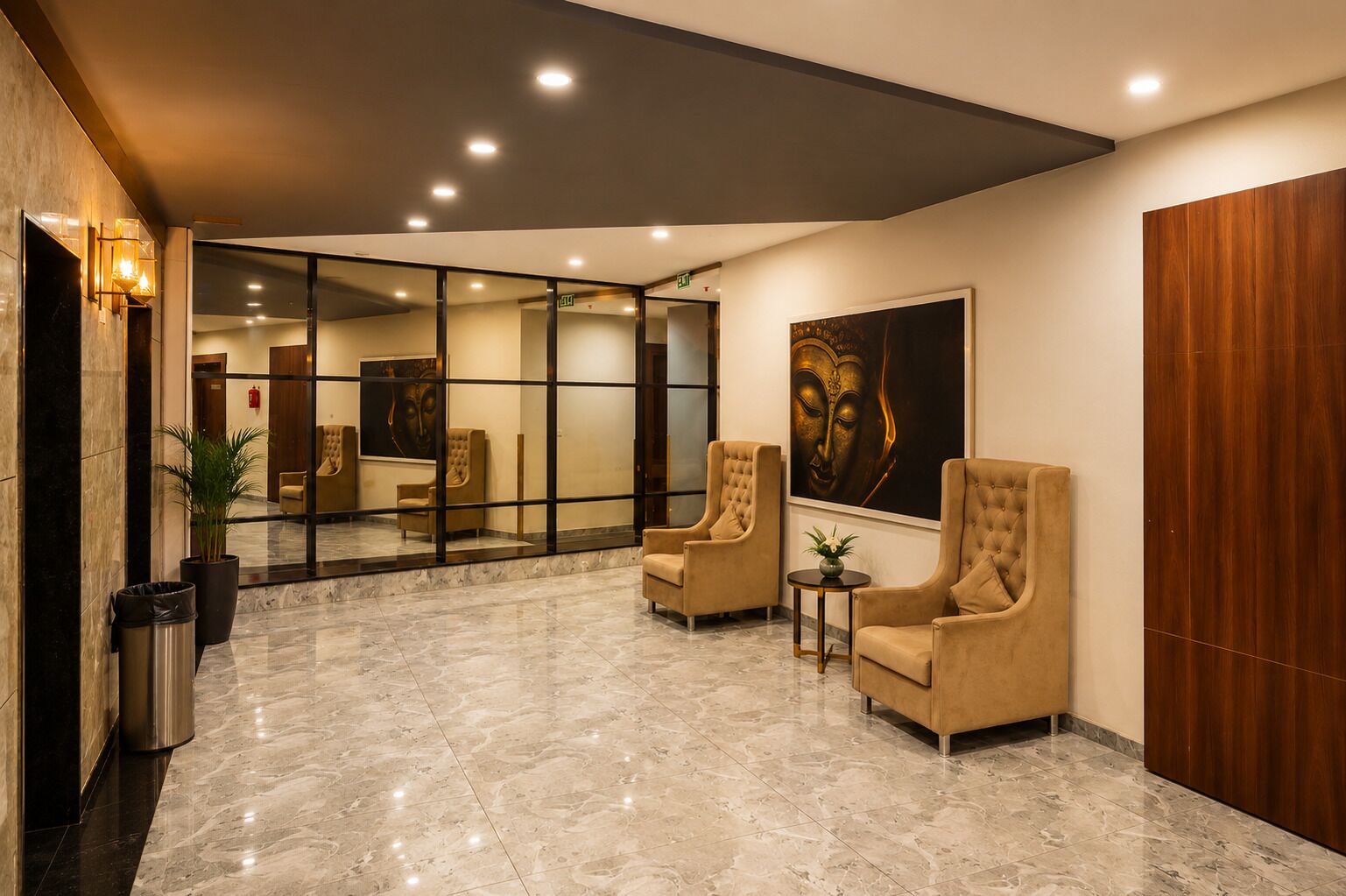 A lobby with marble flooring, two armchairs, a small table, and a Buddha painting.