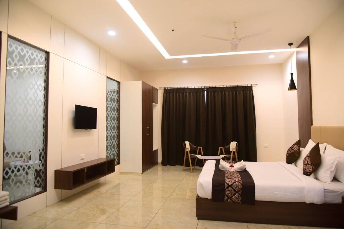 Una habitación de hotel moderna con cama, televisión, escritorio y silla.