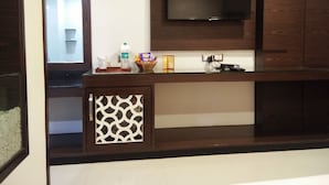 A modern kitchen with a built-in TV, wooden cabinets, and a patterned cabinet door.