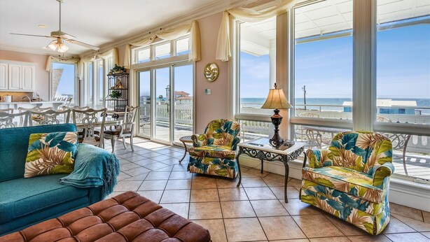 A spacious balcony with a view of the ocean, furnished with a sofa, chairs, and a table. - You will delight in the fabulous gulf views from this elegant, Nantucket style beach home! (St. George Island)