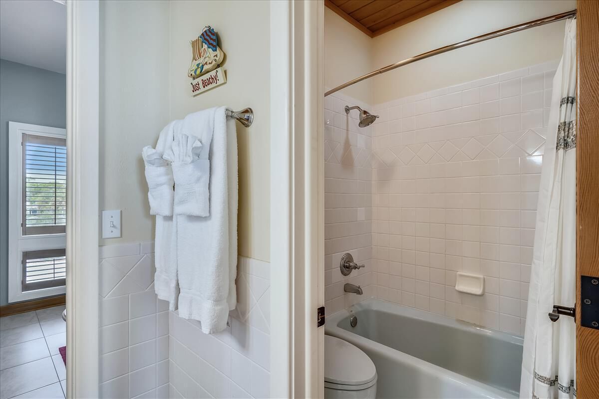 Une salle de bain équipée d’une baignoire, de toilettes et d’un porte-serviettes avec plusieurs serviettes.